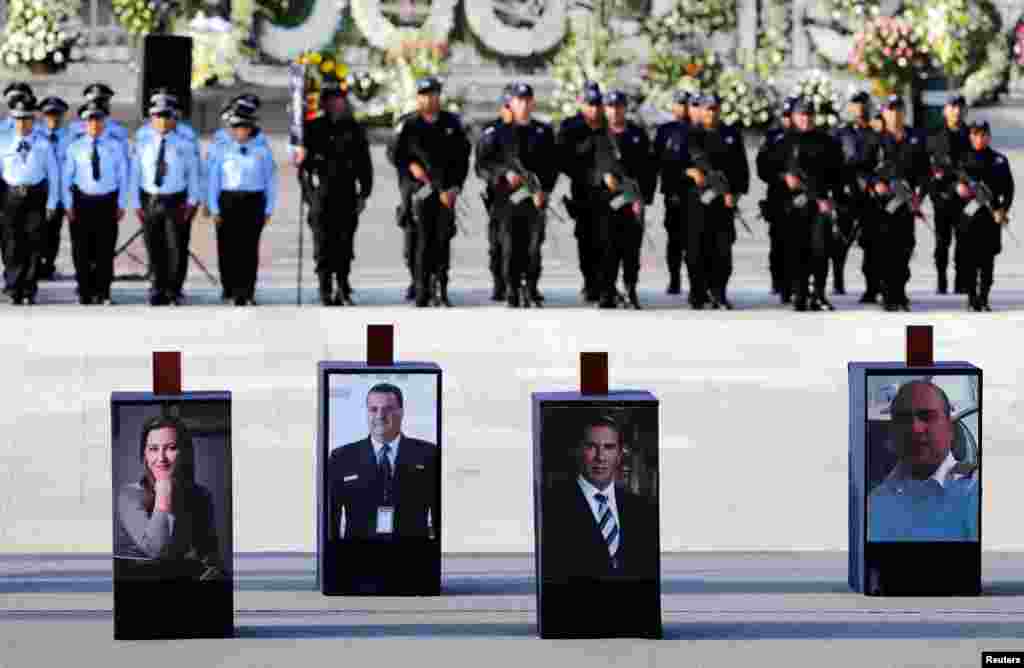 Urns with ashes of Martha Erika Alonso (L), a senior opposition figure and governor of the state of Puebla, her husband Rafael Moreno (C), a senator and former Puebla governor, and two crew members, who died in a helicopter crash, are displayed over their photographs during a homage in Puebla, Mexico, Dec. 25, 2018.