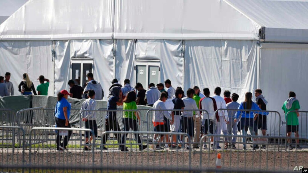 Niños inmigrantes centroamericanos hacen fila para entrar a una casa de campaña en el centro de detención temporal de Homested, Florida. [Foto: Archivo]