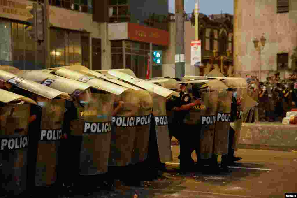 Police officers form a wall using riot shields in Lima, Peru, during a protest against rising fuel and fertilizer prices triggered by the Ukraine conflict, April 5, 2022.