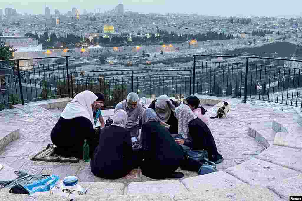 A Muslim family break their fast by a location overlooking Jerusalem's Old City during the holy month of Ramadan, April 5, 2022.