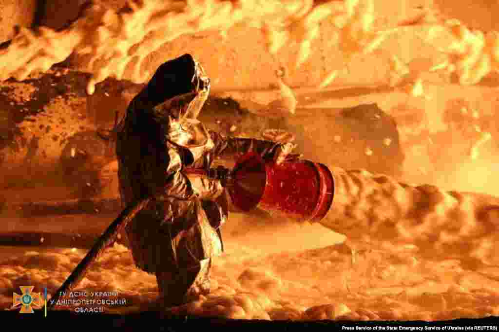 A firefighter works at the site of burning fuel storage facilities damaged by an airstrike in the Dnipropetrovsk region of Ukraine amid Russia's invasion of Ukraine.