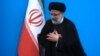 FILE - Iranian President Ebrahim Raisi places his hands on his heart as a gesture of respect as he leaves after a press conference in Tehran, Iran, Aug. 29, 2023.