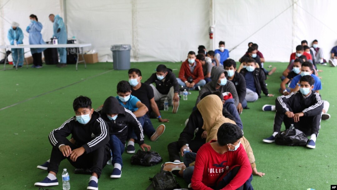 FILE - In this March 30, 2021, young migrants wait to be tested for COVID-19 at the Donna Department of Homeland Security holding facility, the main detention center for unaccompanied children in the Rio Grande Valley, in Donna, Texas. 
