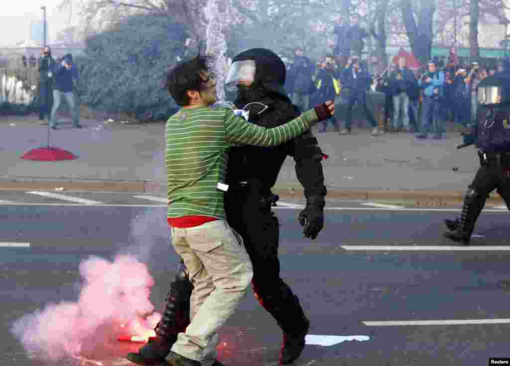 A policeman stops a 'Blockupy' anti-capitalist protester near the European Central Bank (ECB) building before the official opening of its new headquarters in Frankfurt, Germany.