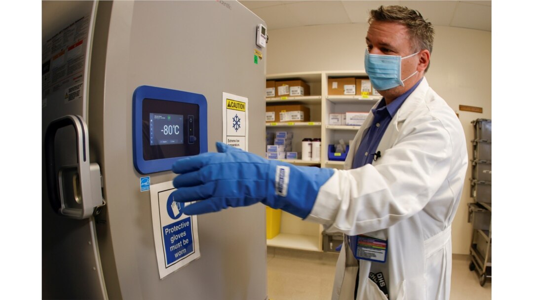 Pharmacy supervisor Kevin Weissman wears a thick glove as he opens the door of a special freezer that will hold the Pfizer vaccine at LAC USC Medical Center, during the outbreak of the coronavirus disease, in Los Angeles, California, Dec. 10. 2020.