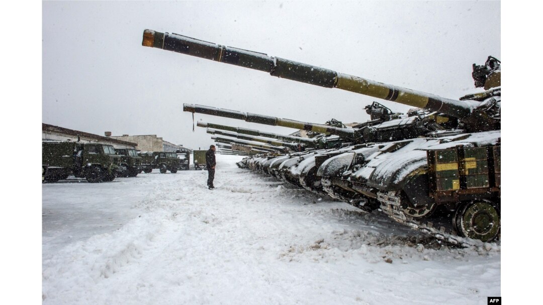 Un militar de las Fuerzas Militares de Ucrania se para frente a los tanques de la brigada 92 mecanizada separada de las Fuerzas Armadas de Ucrania, estacionados en su base cerca de la aldea de Klugino-Bashkirivka, en la región de Kharkiv el 31 de enero de 2022