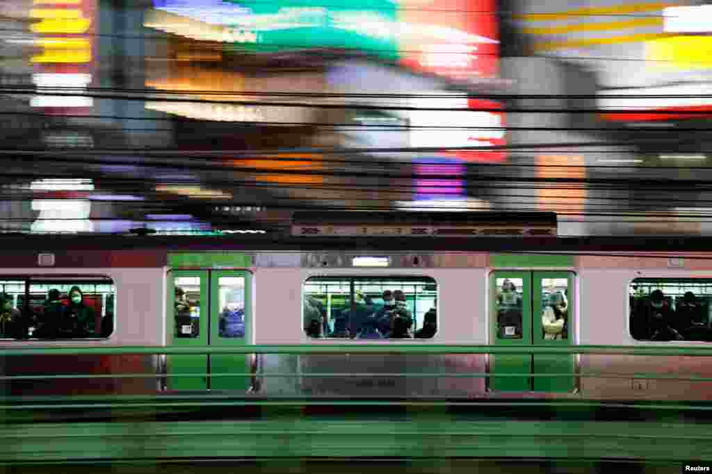 Passengers wearing protective face masks are seen inside a train in Tokyo, Japan.