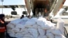 In this photo released by the official Syrian state news agency SANA, workers unload humanitarian aid sent from Arminia for Syria following a devastating earthquake, at the airport in Aleppo, Syria, Feb. 9, 2023.