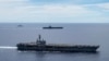 FILE - In a photo provided by the U.S. Navy, U.S. warships sail together in formation, in the South China Sea, July 6, 2020.