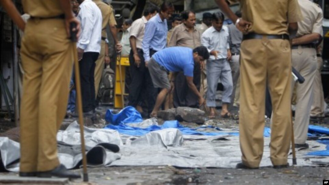 A man moves debris during a clean-up operation near the Opera House, one of the sites of Wednesday's triple explosions, in Mumbai, India, July 15, 2011.