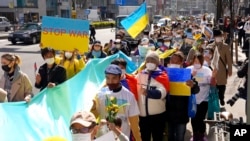 Protesters hold banners and flags during a march denouncing Russia's invasion of Ukraine, in Tokyo, Saturday, March 5, 2022. (AP Photo/Chisato Tanaka)