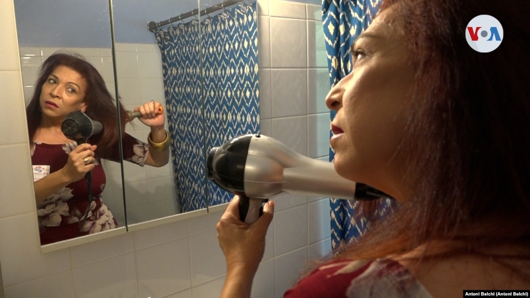 Arianna Lint, una mujer transgénero que llegó a EE. UU. hace 22 años, se alista en el baño de su casa antes de salir a trabajar. Foto: Antoni Belchi / VOA
