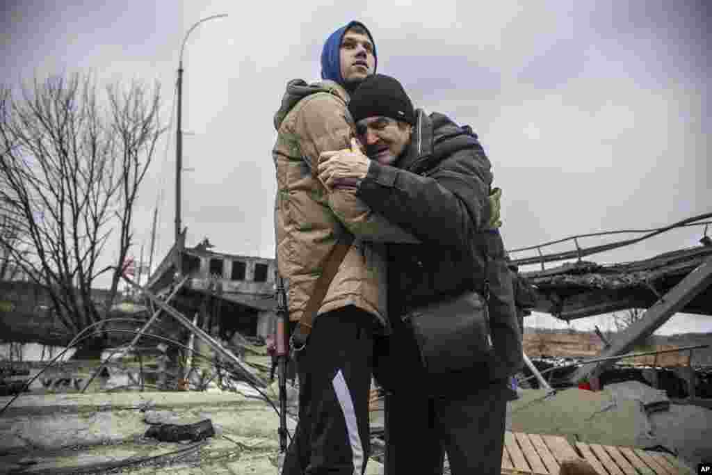 A member of the Ukrainian Territorial Defense Forces hugs a resident who is leaving his hometown after Russian artillery shelling in Irpin, on the outskirts of Kyiv.