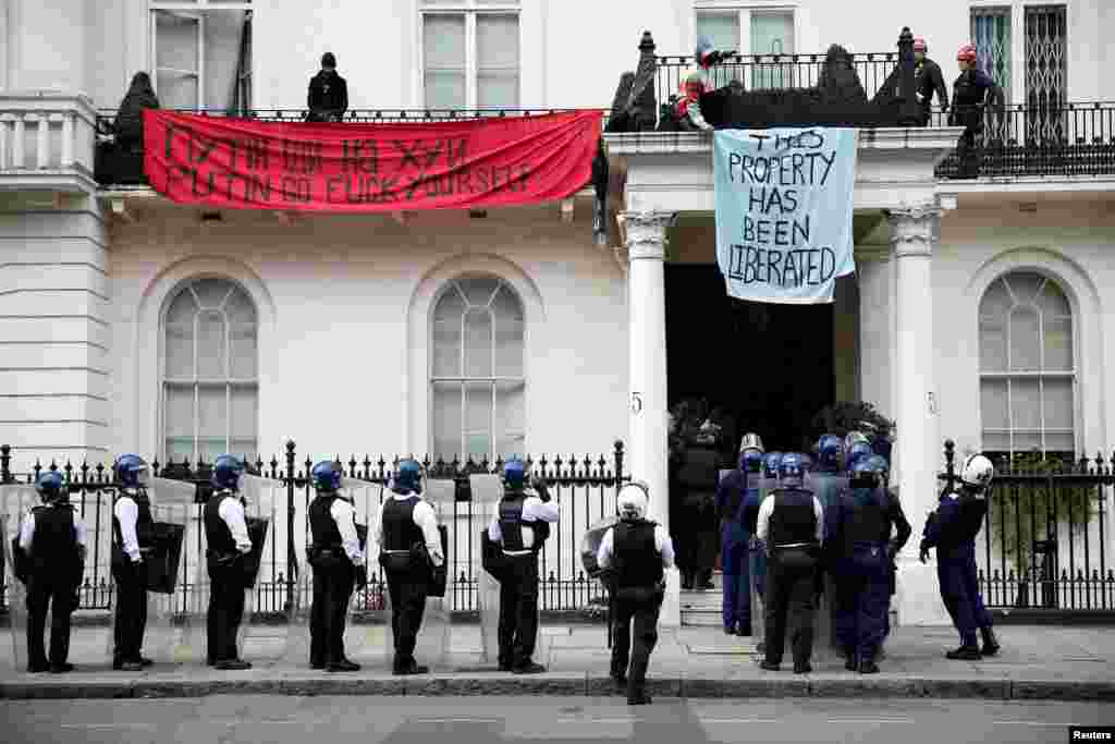 Police officers prepare to enter a mansion reportedly belonging to Russian billionaire Oleg Deripaska, who was placed on Britain's sanctions list last week, as squatters occupy it, in Belgravia, London.