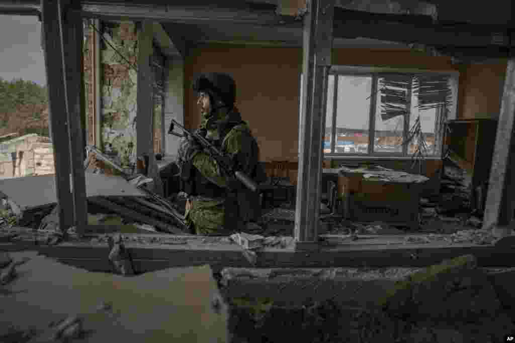 A Ukrainian serviceman stands in a heavily damaged building in Stoyanka. Ukrainian President Volodymyr Zelenskyy accused the West of lacking courage as his country fights to stave off Russia's invading troops, making an exasperated plea for fighter jets and tanks to sustain a defense in a conflict that has ground into a war of attrition.