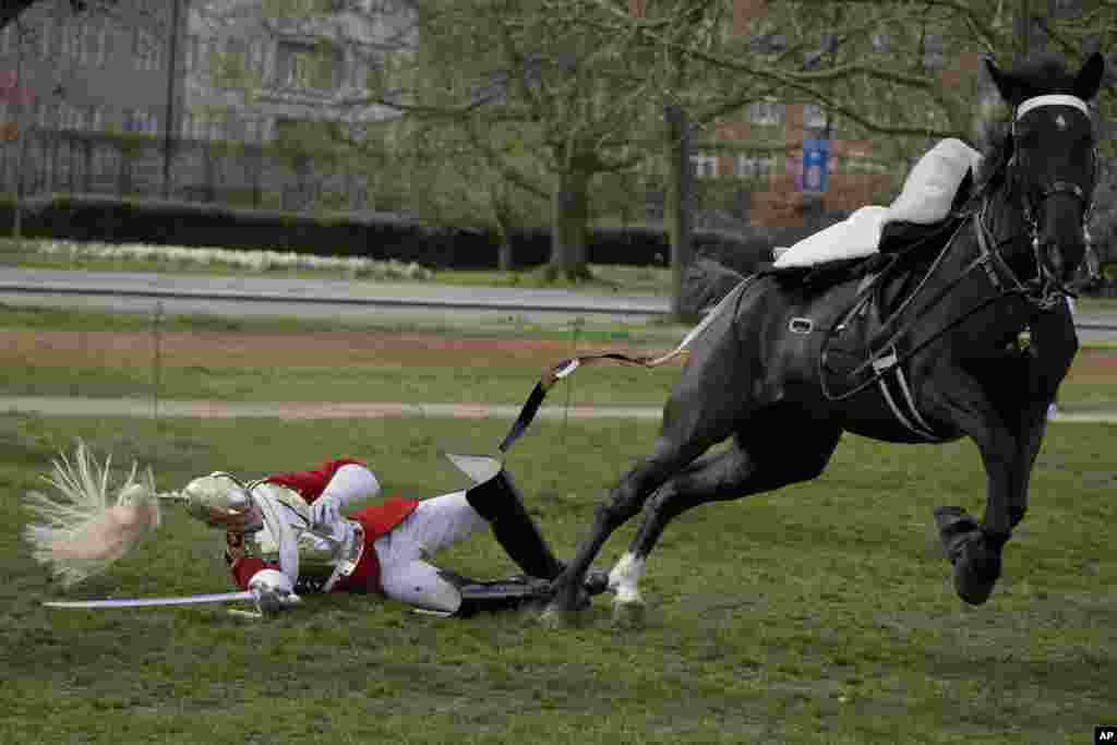 A soldier of the Household Cavalry Mounted Regiment falls off a horse during a practice for this year's Platinum Jubilee celebrations at Hyde Park in London.
