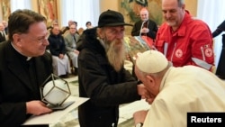 El papa Francisco besa la mano de un hombre durante la celebración de su 86 cumpleaños mientras se reúne con la delegación del Premio Madre Teresa en el Vaticano, el 17 de diciembre de 2022.