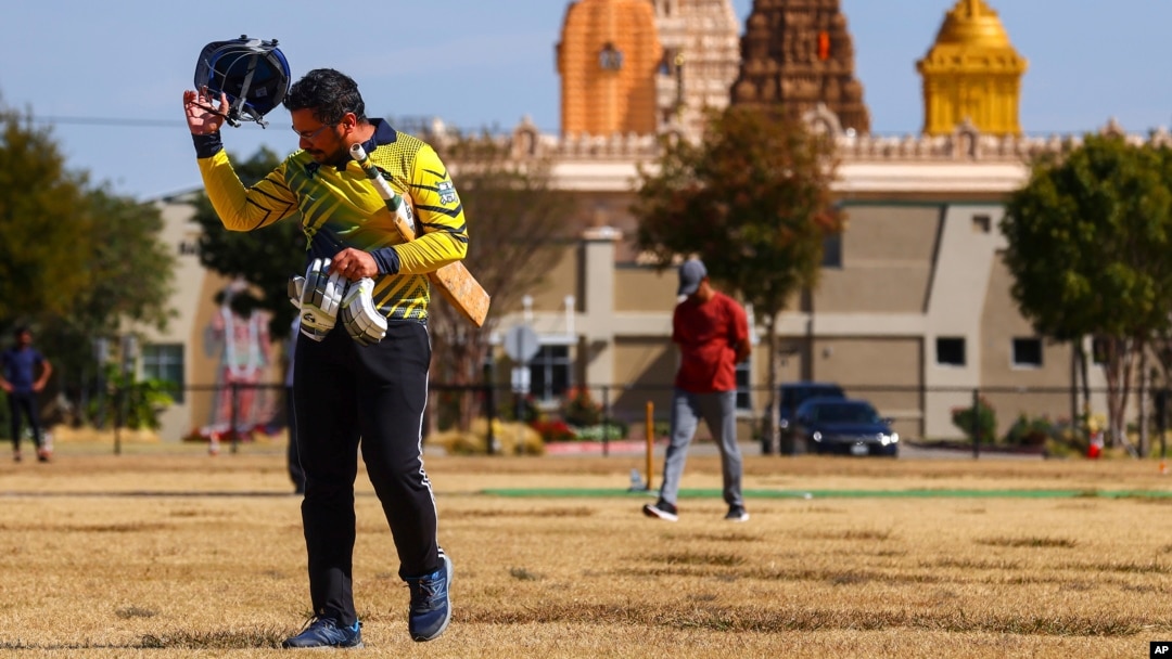 Pavan Kumar Machiraju walks off the field after batting during a cricket match between the Dallas Cricket Connections and the Kingswood Cricket Club, as the Karya Siddhi Hanuman Temple is seen in the background, in Frisco, Texas, Oct. 22, 2022. (AP Photo/Andy Jacobsohn)