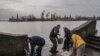 Los residentes de la ciudad recientemente liberada de Jersón recogen agua de la orilla del río Dnipro, cerca de la línea del frente, en el sur de Ucrania, el lunes 21 de noviembre de 2022. (Foto AP/Bernat Armangue)