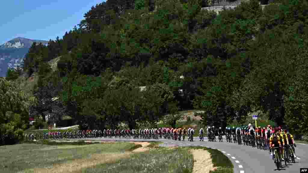 The pack of riders cycle during the sixth stage of the 74th edition of the Criterium du Dauphine cycling race, 196.5 km between Rives and Gap, central eastern France.