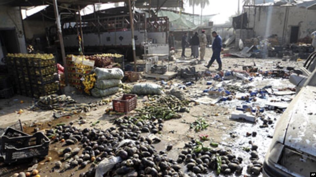 Residents and Iraqi soldiers inspect the site of a bomb attack in Khalis, northeast of Baghdad, December 1, 2011