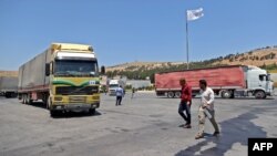 FILE - A convoy transporting humanitarian aid crosses into Syria from Turkey through the Bab al-Hawa border crossing on July 8, 2022. 