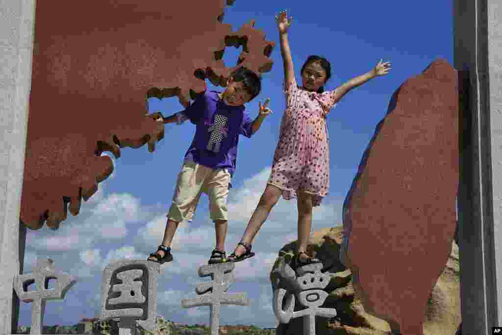 Children pose for photos at the 68-nautical-mile scenic spot, the closest point in mainland China to the island of Taiwan, in Pingtan in southeastern China's Fujian Province. China conducted "precision missile strikes" Thursday in waters off Taiwan's coasts as part of military exercises that have raised tensions in the region to their highest level in decades.