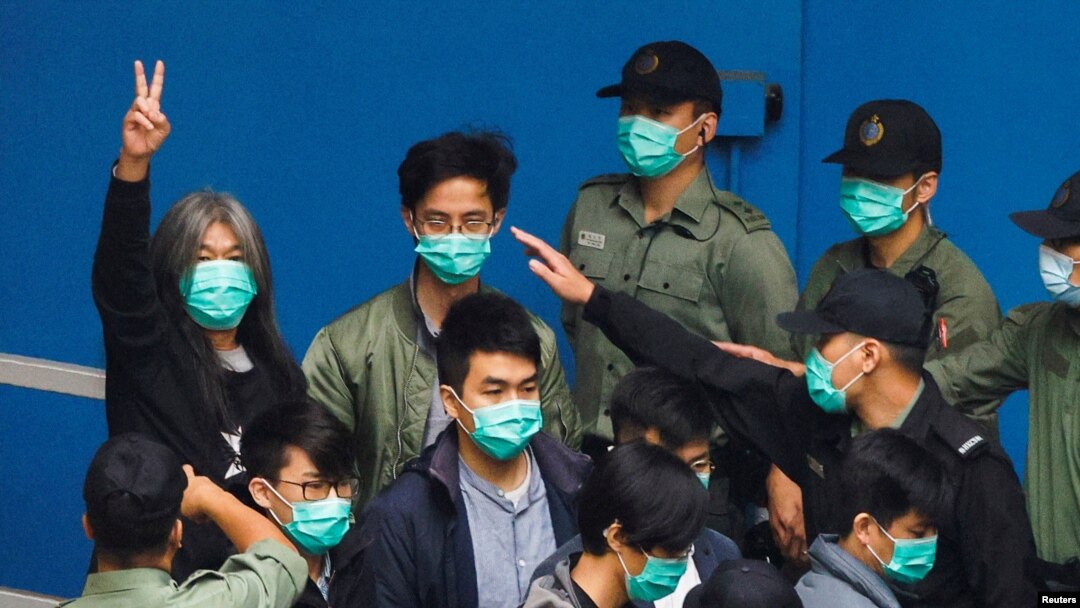 FILE - Pro-democracy activist Leung Kwok-hung, also known as 'Long Hair,' gestures as he walks to a prison van with other activists to head to court over a national security law charge, in Hong Kong, March 4, 2021.