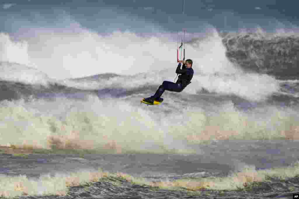 A kite surfer enjoys strong winds and surf at Birubi Point in Anna Bay, Australia.