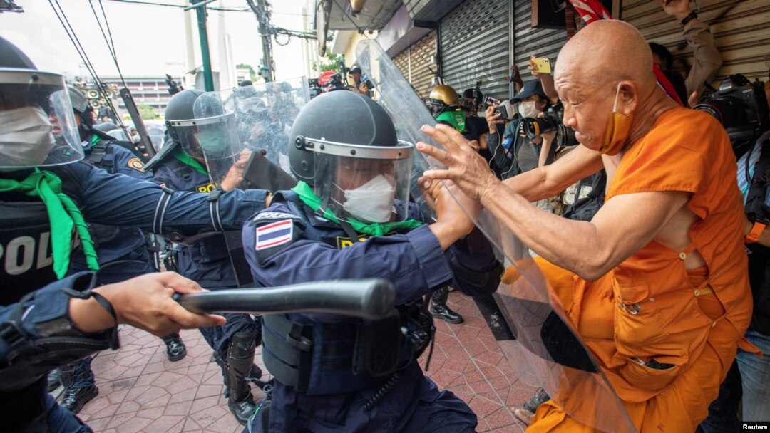A protester clashes with riot police officers during a protest against the Asia-Pacific Economic Cooperation (APEC) Summit 2022, near the Democracy Monument in Bangkok, Thailand.
