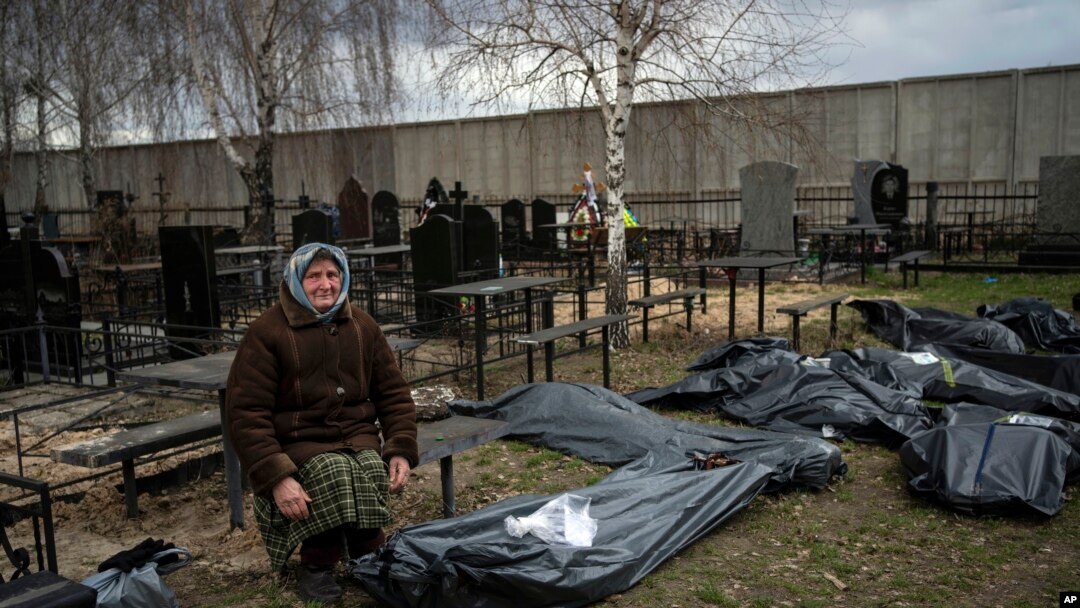 FILE - Nadiya Trubchaninova, 70, sits next to a bag containing the body of her son, who was killed by Russian soldiers on March 30, 2022, near Kyiv, Ukraine, April 12, 2022. Experts from several countries are investigating who can be prosecuted for crimes of aggression.