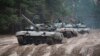 FILE - Ukrainian soldiers riding on captured Russian T-72 tanks conduct military training close to the Ukraine-Belarus border, near Chernihiv, Ukraine, Oct. 28, 2022. Navigating the terrain will soon be a challenge for Ukrainian and Russian troops as winter arrives.