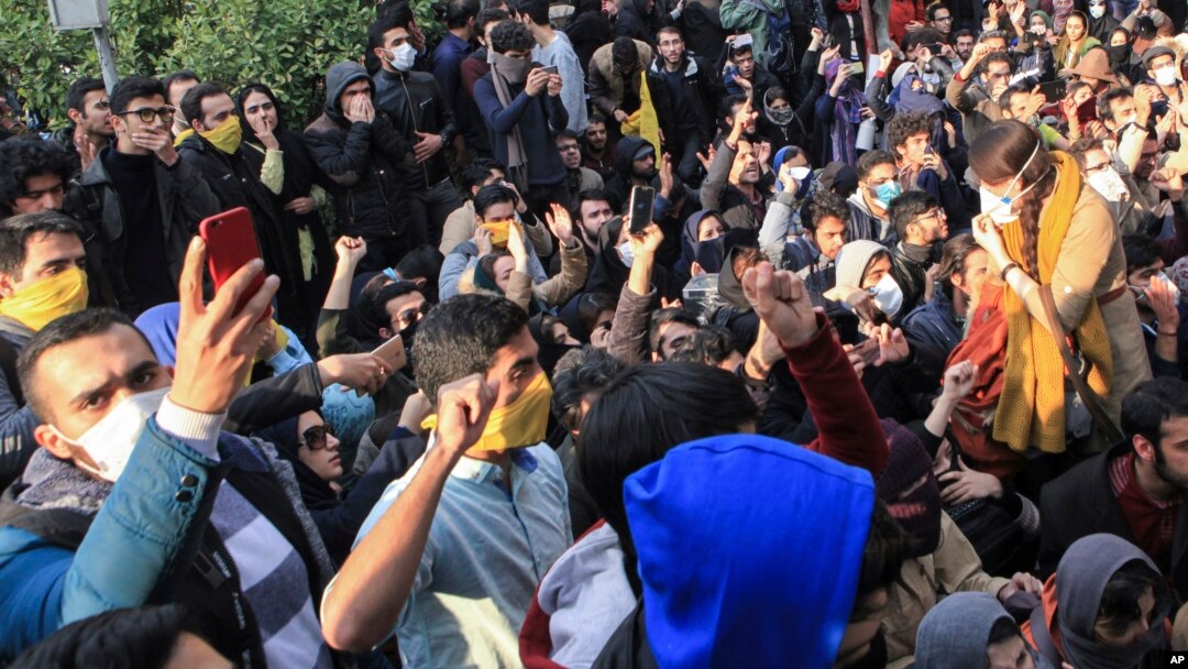 In this Saturday, Dec. 30, 2017 file photo taken by an individual not employed by the Associated Press and obtained by the AP outside Iran, university students attend a protest inside Tehran University while anti-riot Iranian police prevent them to join o