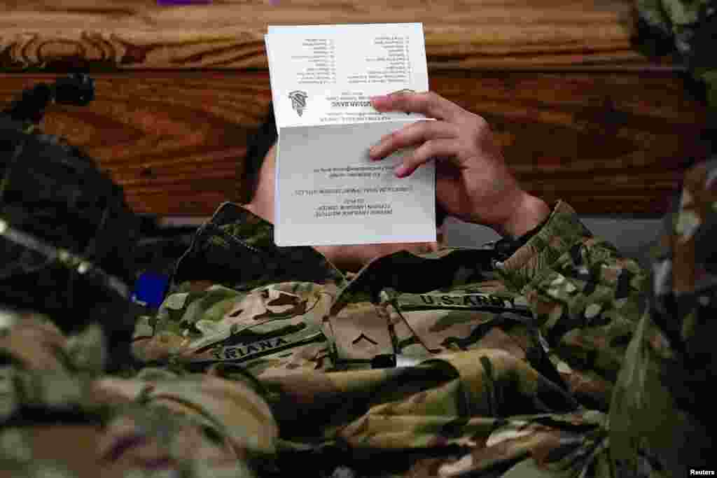 A soldier from the 82nd Airborne Division reads a Russian language study guide before boarding a C-17 transport plane for deployment to Eastern Europe amid escalating tensions between Ukraine and Russia, at Fort Bragg, North Carolina, Feb. 6, 2022.