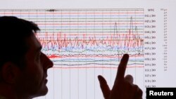 FILE - A seismologist points to a seismographic graph in this undated photo. A magnitude-7.6 earthquake shook the Caribbean Sea south of the Cayman Islands on Feb. 8, 2025, according to the U.S. Geological Survey. 