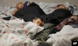 Niños detenidos en la frontera duermen en una celda de retención en una instalación de procesamiento de inmigrantes ilegales en Brownsville, Texas. Junio 18, 2014.