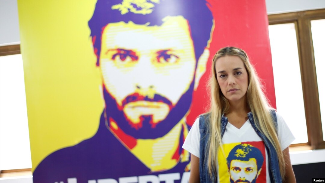 FILE - Lilian Tintori, wife of jailed Venezuelan opposition leader Leopoldo Lopez, stands near a poster depicting him at the Popular Will party's office in Caracas, Venezuela, Jan. 18, 2017.