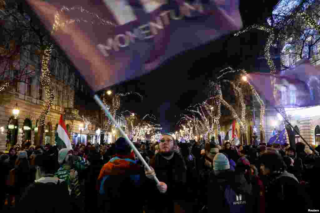 People march during a protest against a proposed new labor law dubbed as the 'slave law,' in front of the Parliament building in Budapest, Hungary.