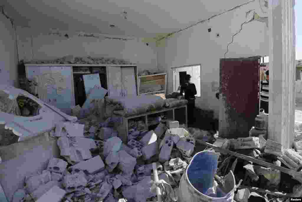 Men inspect a damaged room at a site hit by what activists said were barrel bombs dropped by forces loyal to President Bashar al-Assad, in al-Letmana village, Hama province, May 1, 2014. 