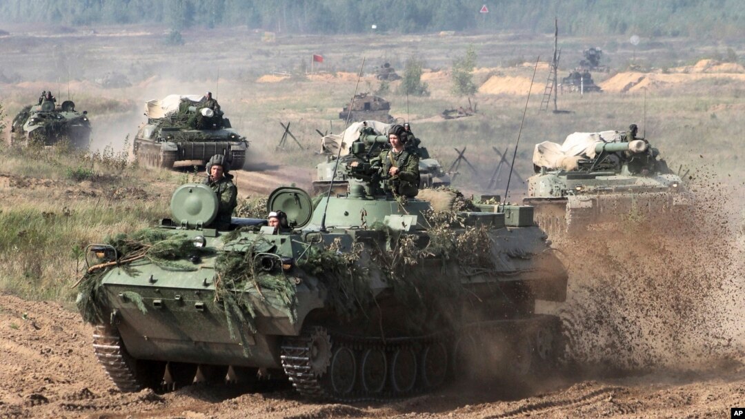 FILE - Belarusian army vehicles drive preparing for war games at an undisclosed location in Belarus, Sept. 11, 2017. Russia and Belarus are holding a massive war games, Zapad 2017, due to start Thursday.