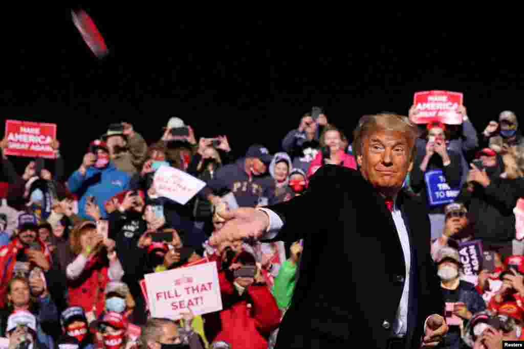 U.S. President Donald Trump throws face masks to the crowd as he arrives to hold a campaign rally at John Murtha Johnstown-Cambria County Airport in Johnstown, Pennsylvania, Oct. 13, 2020.