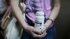 An activist of a non-governmental group, All- Ukrainian Network of People Living With HIV/AIDS, holds an empty package of the drug Aluvia, during a rally in Kyiv to protest the lack of government-supplied medicine, July 1, 2015.