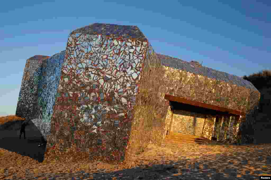 A bunker covered in pieces of broken mirrors by an anonymous, unknown artist is seen during sunset on the beach in Leffrinckoucke, France.