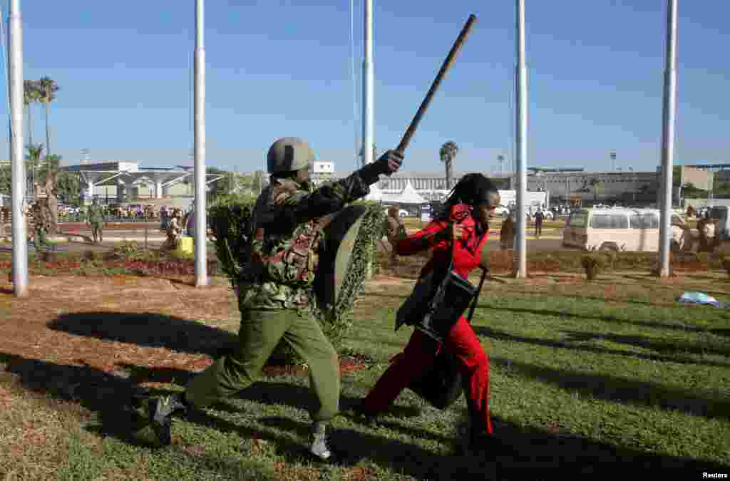A Kenya Airways worker is dispersed by riot police at the Jomo Kenyatta International Airport during a labor dispute that grounded flights near Nairobi.