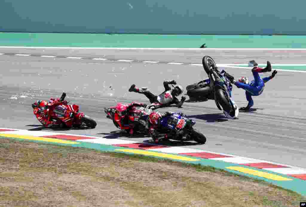 Spain's rider Alex Rins of the Team SUZUKI ECSTAR, top right, and Japan's rider Takaaki Nakagami of the LCR Honda IDEMITSU and Italian rider Francesco Bagnaia of the Ducati Lenovo Team, left, fall during the MotoGP race of the Catalunya Motorcycle Grand Prix at t the Catalunya racetrack in Montmelo, just outside of Barcelona, Spain.