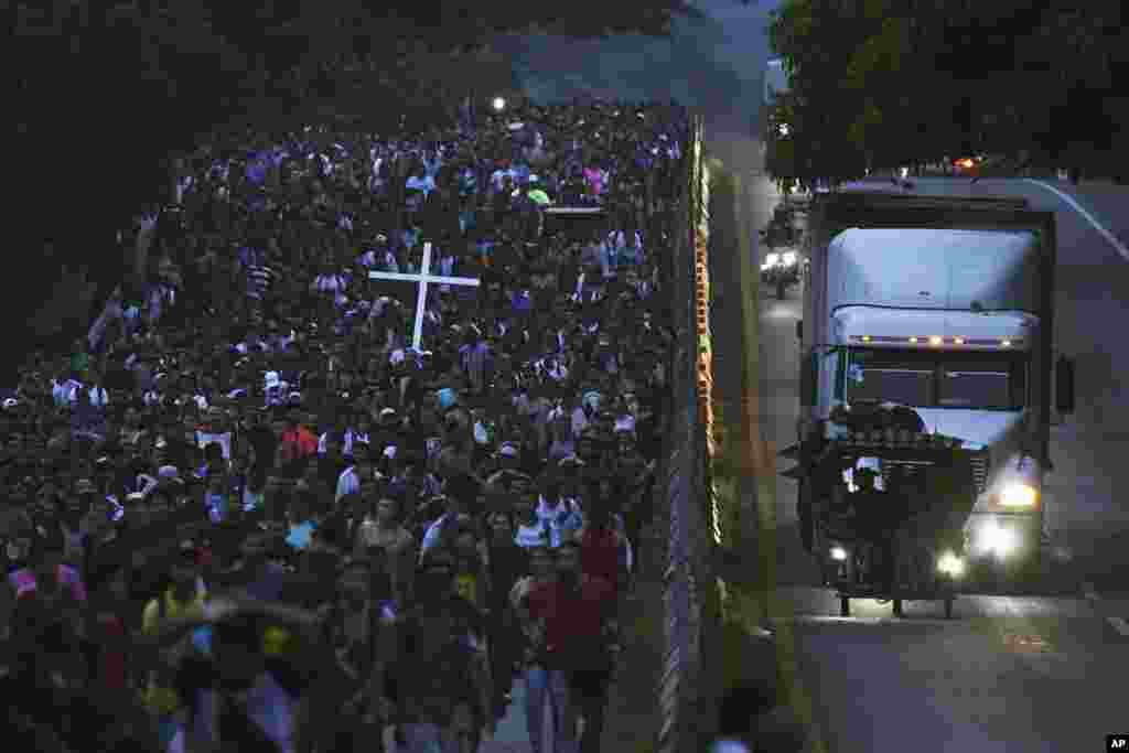 Migrants, many from Central American and Venezuela, walk along the Huehuetan highway in Chiapas state, Mexico. The group left Tapachula, tired of waiting to normalize their status in a region with little work and still far from their ultimate goal of reaching the United States.