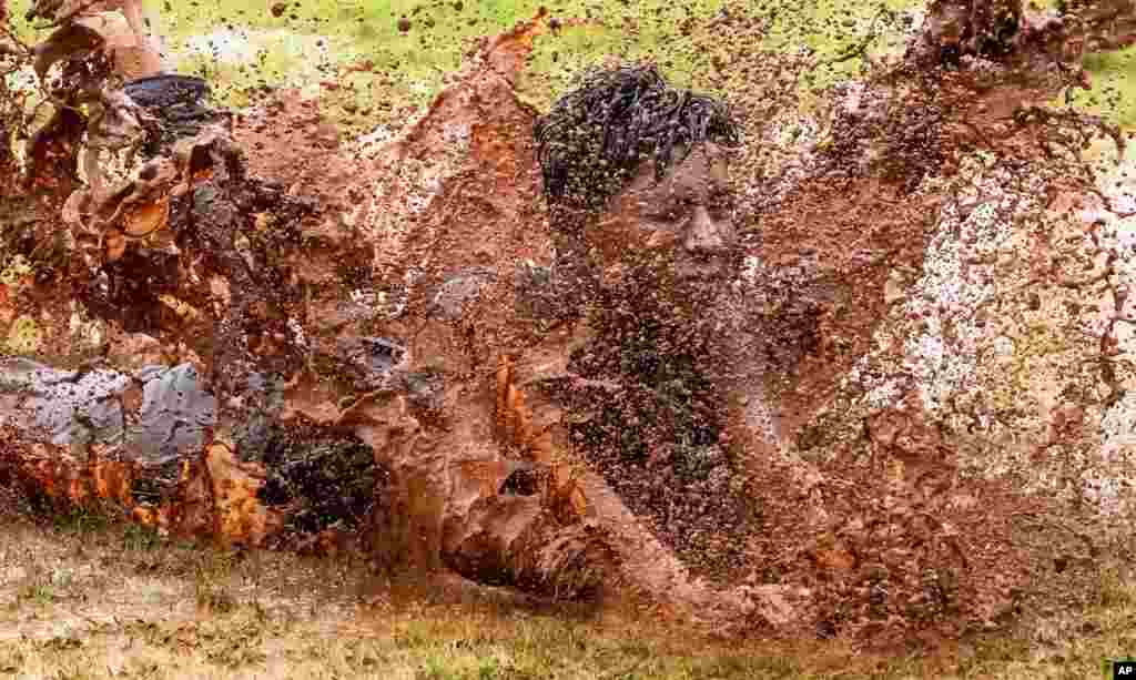 A boy dives in a puddle of muddy water as he enjoys the rains in Mumbai, India, June 27, 2022.