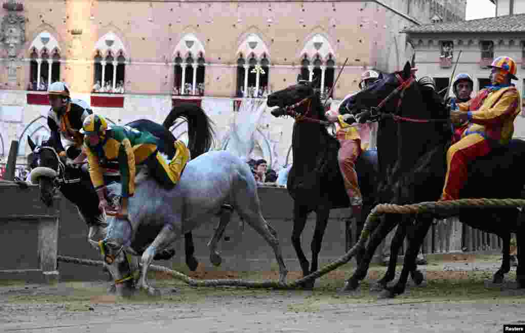 Bruco parish jockey Stefano Piras falls during a false start of his horse 'Uragano Rosso' during the "Palio di Provenzano" horse race in Siena, Tuscany, Italy, July 2, 2022.