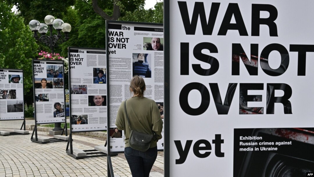A woman visits the photo exhibition 'The war is not over' opened in the Taras Shevchenko park in Kyiv on June 23, 2022.