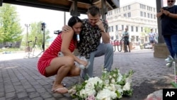 新婚夫婦布魯克與馬特·斯特勞斯在伊利諾伊州芝加哥近郊海蘭帕克的槍擊慘案現場附近留下兩人婚禮上的鮮花並為死難者默哀。 (2022年7月5日)